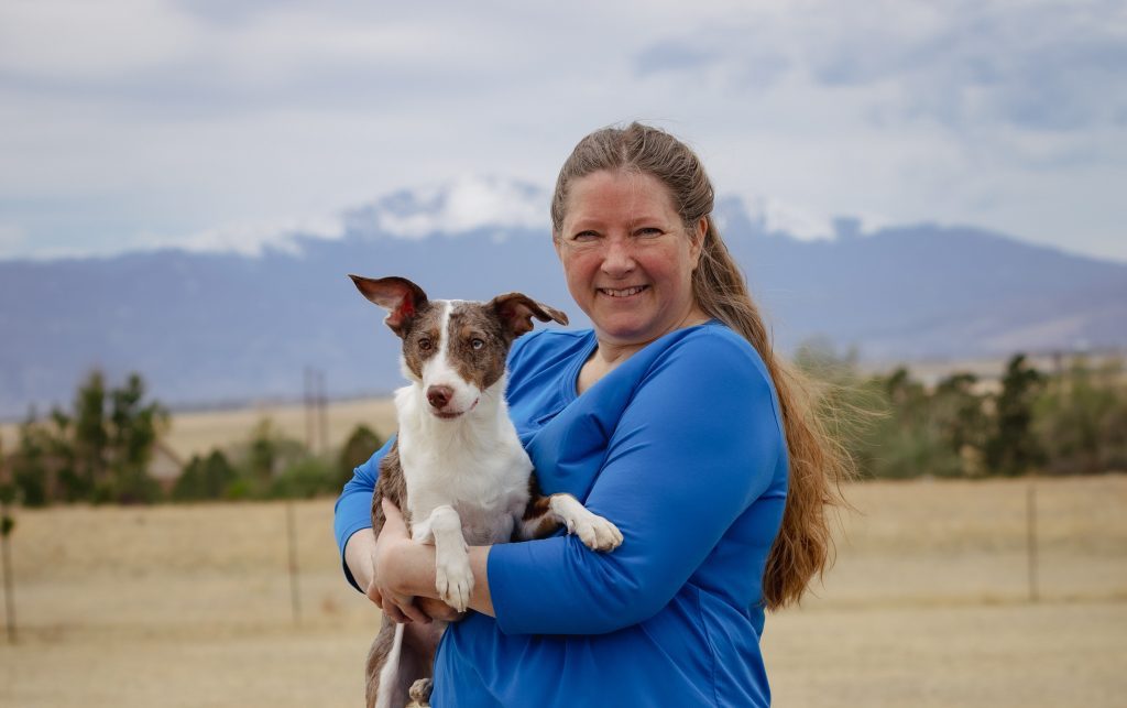 Trick dog and owner with a mountain background